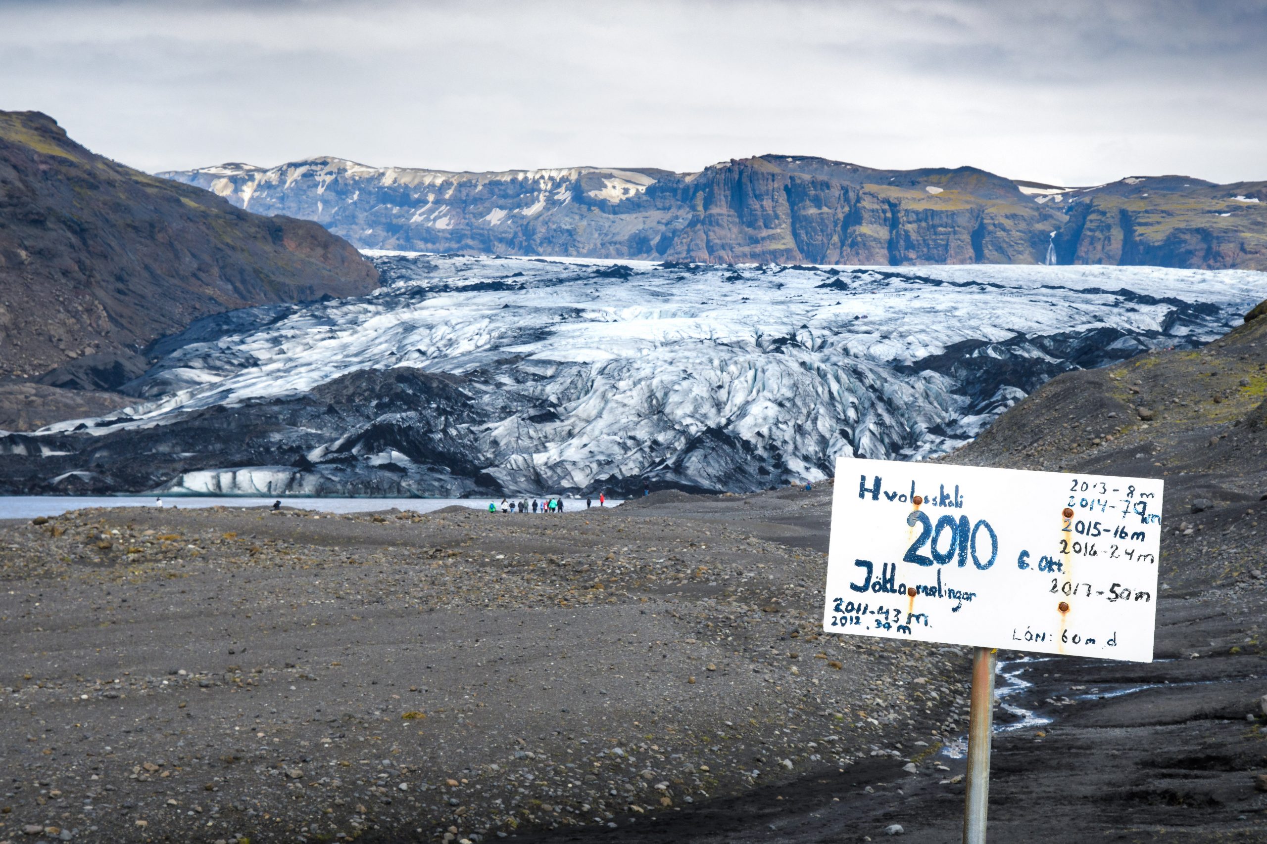 Image shows a low tech, handwritten sign marking the ice recession in Iceland.