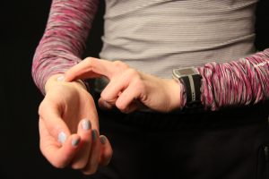 hand taking heart rate with first two fingers on opposite inside of wrist near thumb