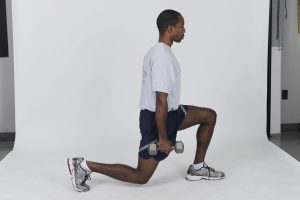 Person performing a lunge holding dumbbells