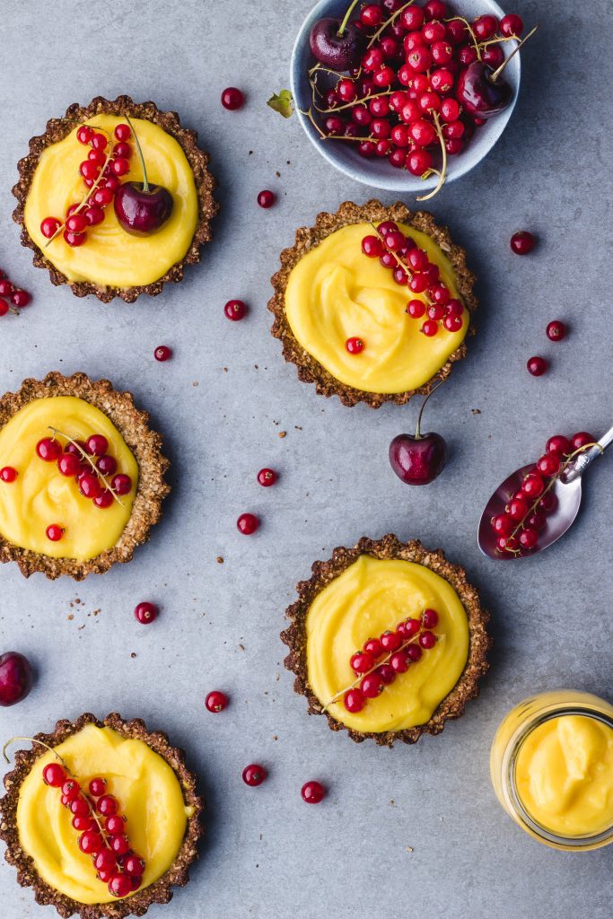 small lemon curd pies with red berries on top
