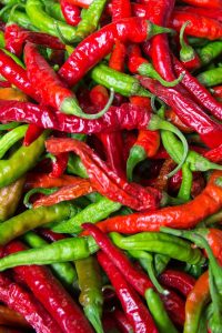 Red and Green Chili peppers are sitting in a pile