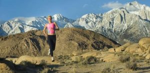 A picture of a woman running in the mountains