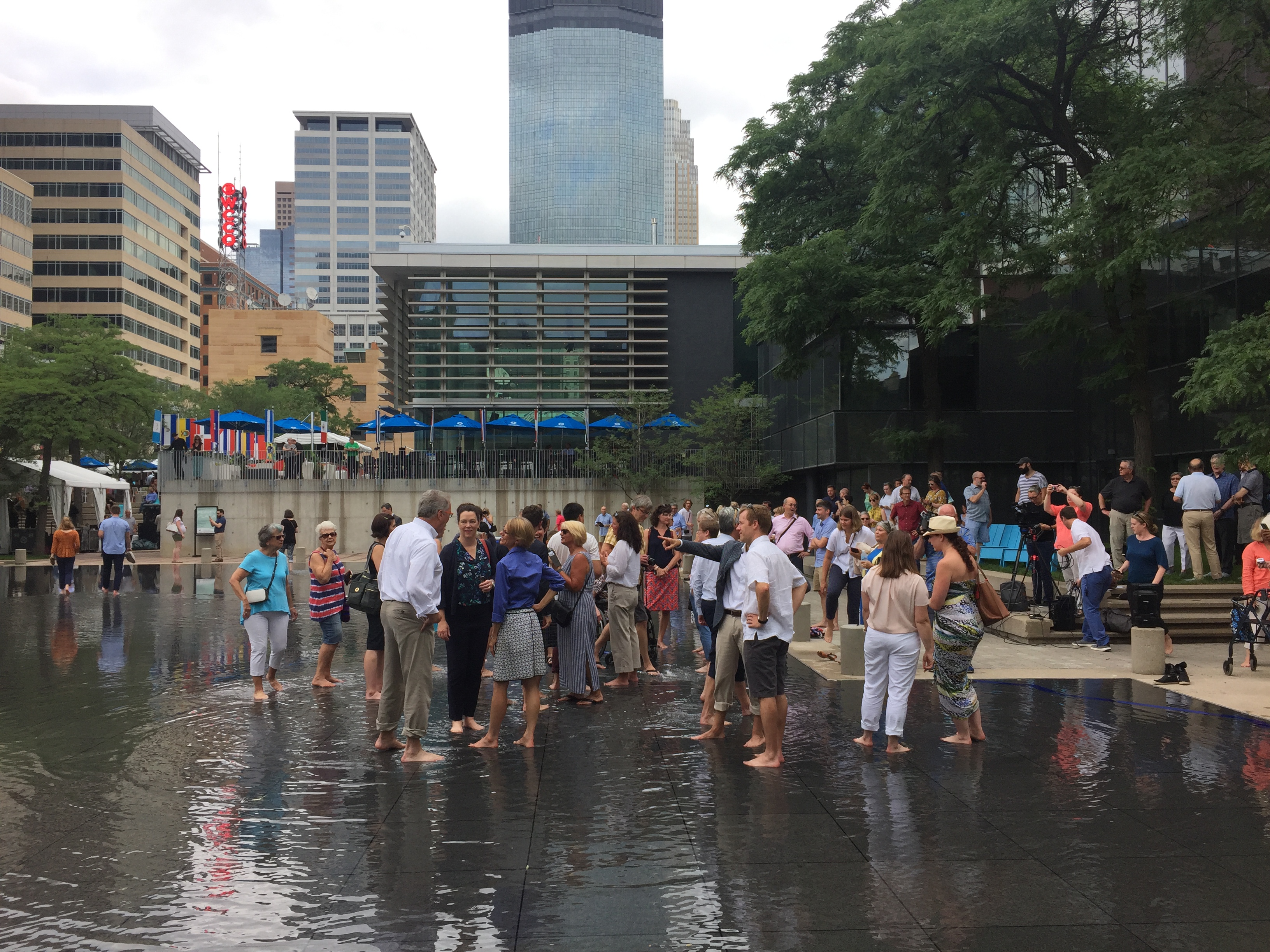 People wading in a shallow pond at the Peavey Plaza grand opening celebration.