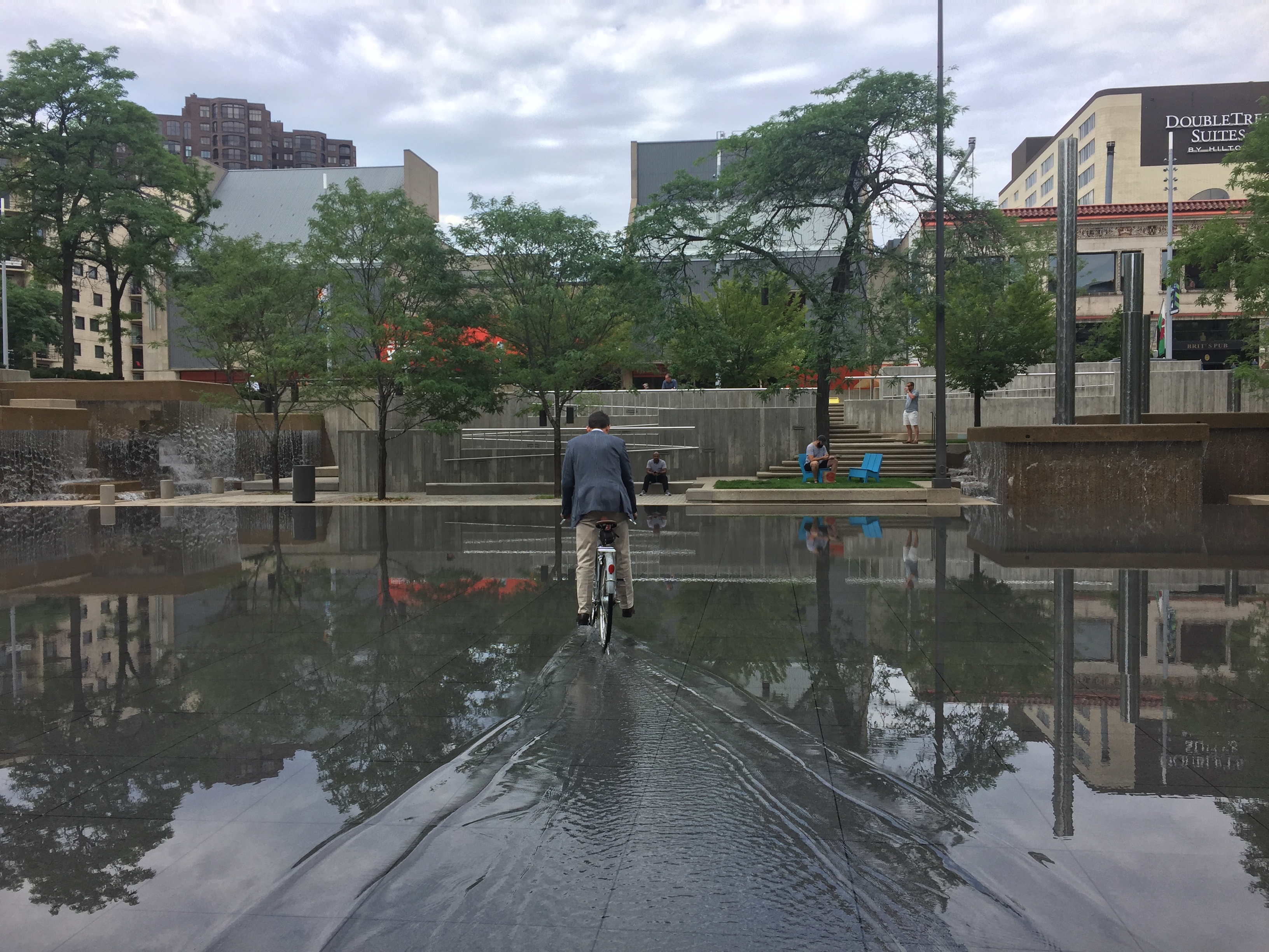 Picture of a bicyclist crossing the shallow water at Peavey Plaza.