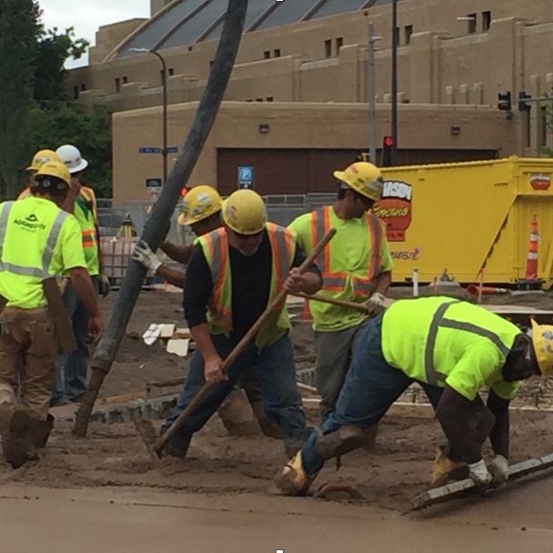 Men in bright yellow shirts working on a project.